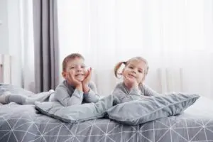 happy kids playing on bed
