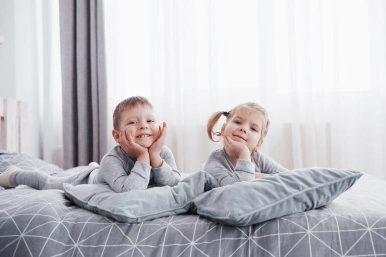 happy kids playing on bed